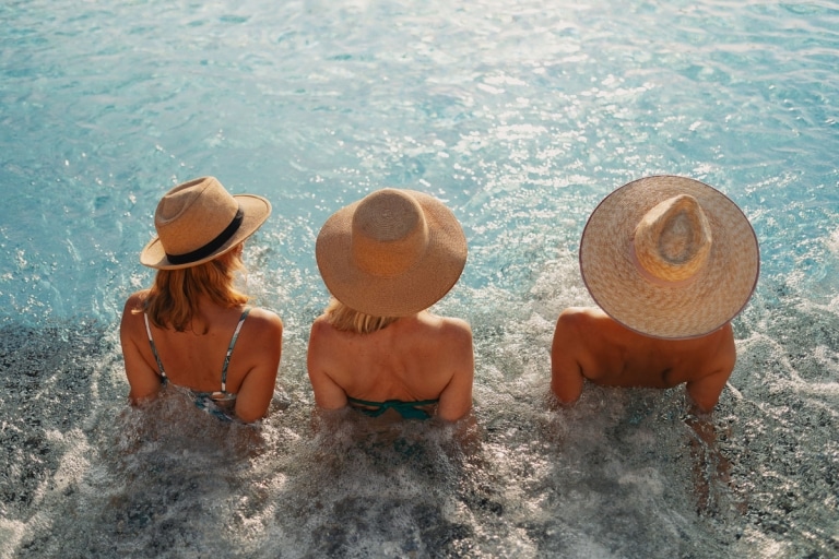 Infinity-Pool-Sommer-Frauen-Freundinnen-Hut-Entspannung-Wellness (c) Hotel Larimar, Karl Schrotter Photograph